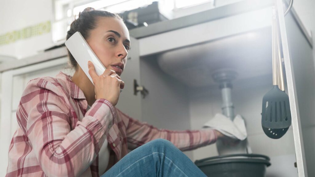 Girl calling a plumber on the phone